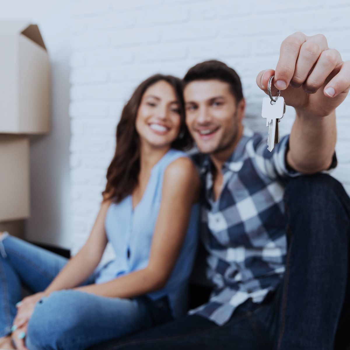 Happy young couple with keys to new rental property, just after moving in. Renting, Lease, Rentals.